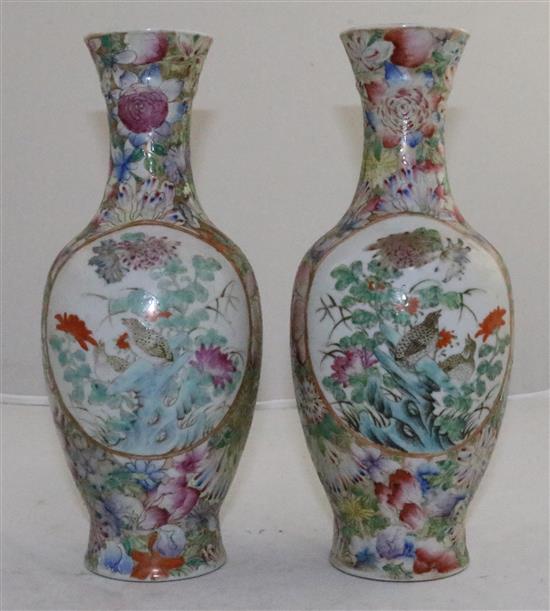 A pair of Chinese famille rose millefleur bottle vases, early 20th century, 24.5cm